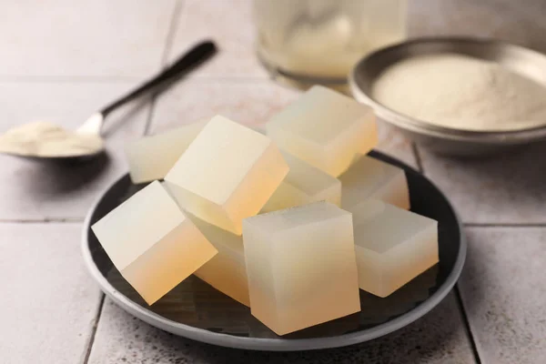 Agar-agar jelly cubes on tiled surface, closeup