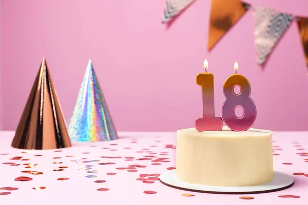 stock image 18th birthday. Delicious cake with number shaped candles for coming of age party on table against lilac background, space for text