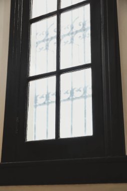 Window with grid on white wall indoors