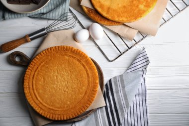 Lezzetli ev yapımı katmanlı kek için malzemeler beyaz ahşap masada düz bir şekilde yatıyordu.