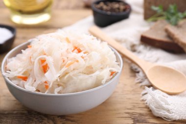Bowl of tasty sauerkraut on wooden table, closeup