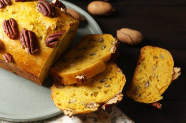Delicious pumpkin bread with pecan nuts on wooden table, closeup