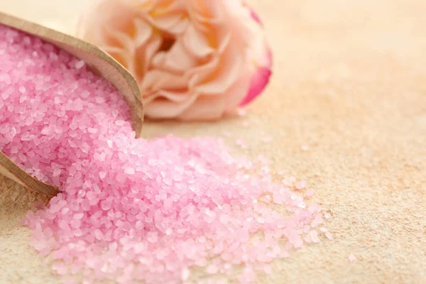 Pink sea salt and beautiful flowers on color textured table, closeup. Space for text