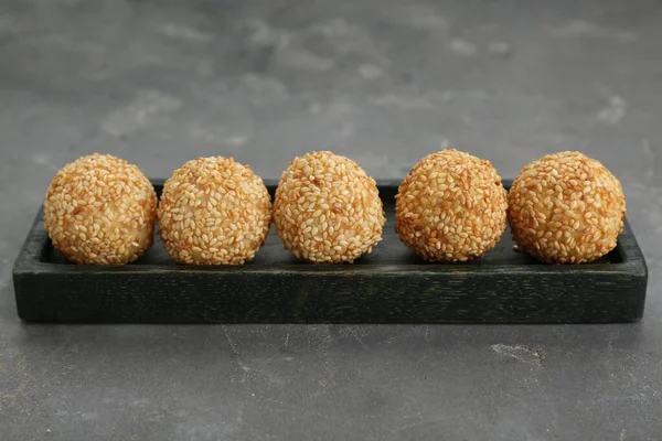 Many delicious sesame balls on grey table