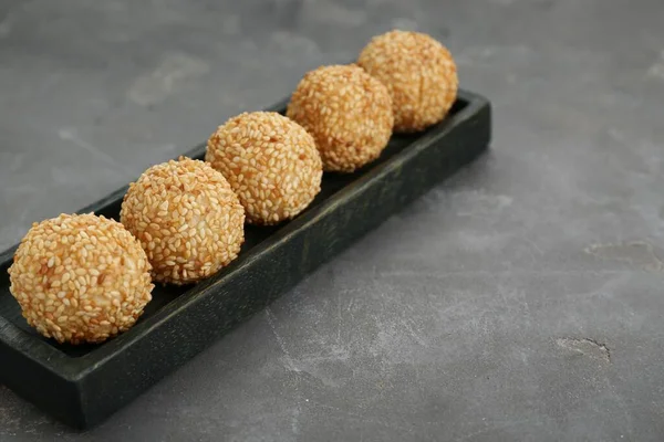Delicious sesame balls on grey table. Space for text