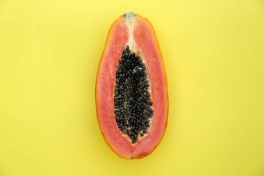 Half of fresh ripe papaya fruit on light green background, top view