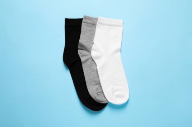 Different socks on light blue background, flat lay