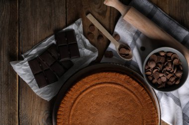 Lezzetli ev yapımı sünger keki ve ahşap masada farklı türde çikolatalar.