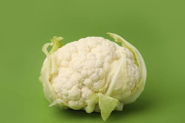 Whole fresh raw cauliflower on green background