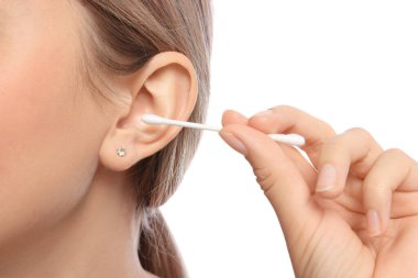 Beyaz arka planda pamuklu çubukla kulak temizleyen genç kadın, yakın plan.