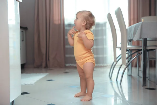 Cute baby learning to walk in room