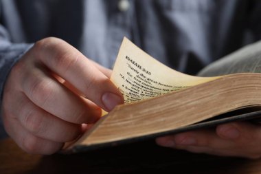 Man reading old holy Bible, closeup view