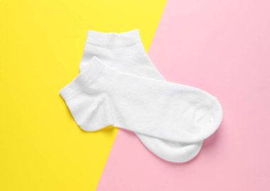 Renkli arka planda bir çift beyaz çorap, düz yatış.