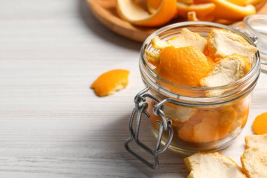 Orange peels preparing for drying on white wooden table, closeup. Space for text