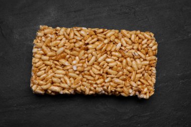 Puffed rice bar (kozinaki) on black table, top view