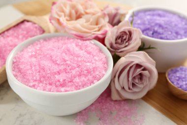 Sea salt and beautiful roses on light grey marble table, closeup