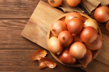 Tahta masada bir sürü olgun soğan var.