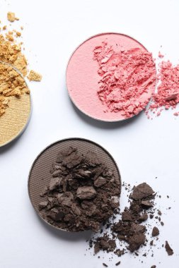 Different crushed eye shadows on white background, flat lay. Professional makeup product