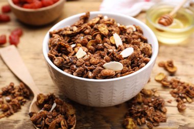 Tasty granola served with nuts and dry fruits on wooden table