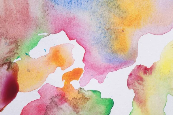 Abstract colorful watercolor painting on white paper, top view