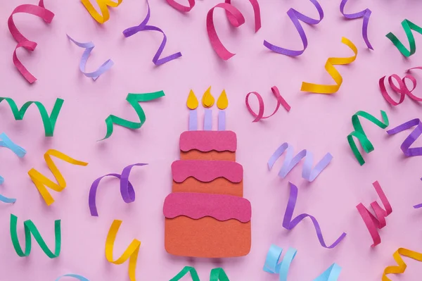 Birthday party. Paper cake and confetti on pink background, flat lay