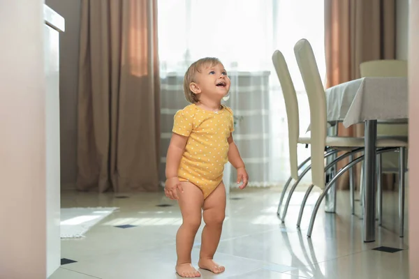 Cute baby learning to walk in room