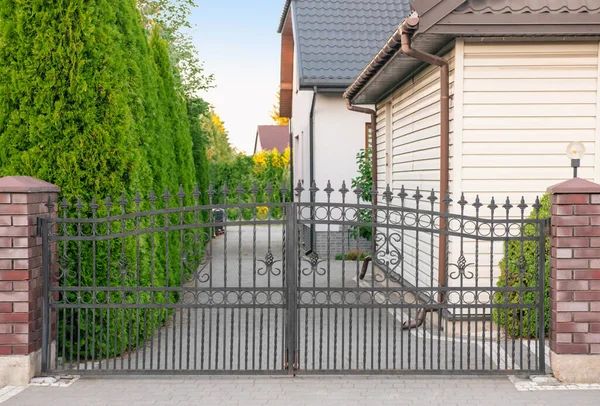 House and gates of beautiful fence with iron railing outdoors