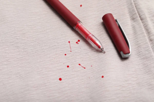 Pen and stains of red ink on shirt, closeup. Space for text