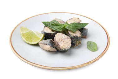 Plate with canned mackerel chunks, lime and basil isolated on white