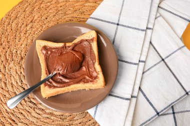Tasty toast with chocolate paste on wicker mat, above view