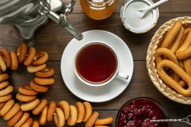 Flat lay composition with delicious ring shaped Sushki (dry bagels) and cup of tea on wooden table