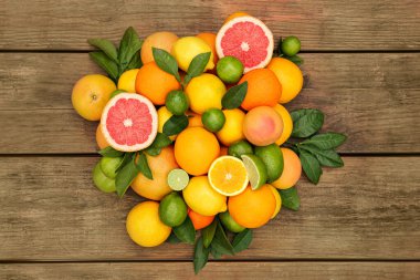 Tahta masada yeşil yapraklı farklı narenciye meyveleri vardı.