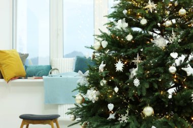 Beautiful Christmas tree decorated with baubles in stylish room. Interior design