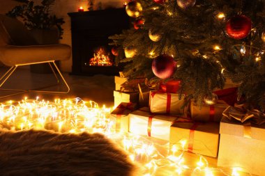 Beautiful Christmas tree, fairy lights and gifts indoors