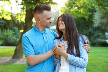 Happy young couple having good time together in park