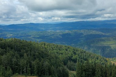 Dağ manzarası ve bulutlu gökyüzü.