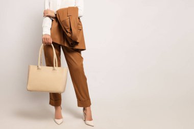 Beyaz arka plan üzerinde şık çanta ile genç kadın, closeup