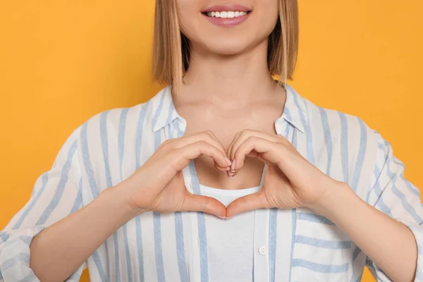 Young Woman Making Heart Hands Yellow Background Closeup Volunteer Concept — Stockfoto