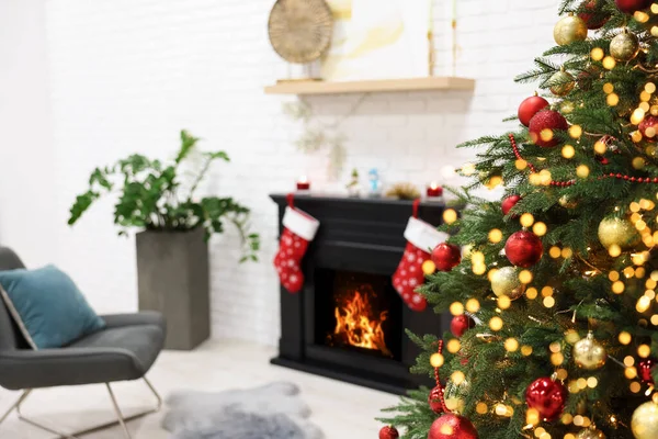 Beautiful Christmas tree near fireplace in room. Interior design