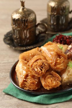 Tea and baklava dessert and Turkish delight served in vintage tea set on wooden table, closeup. Space for text