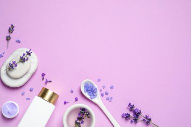 Kozmetik ürünleri ve eflatun çiçekleri eflatun arka planda, düz yerde. Metin için boşluk