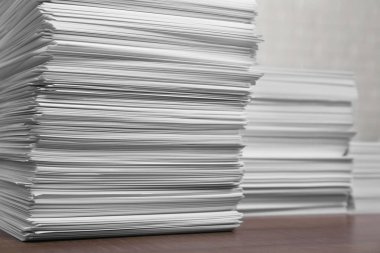 Stacks of white paper sheets on wooden table