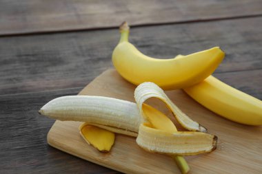 Delicious yellow bananas on wooden table, closeup