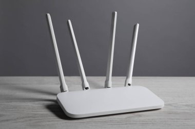 New stylish Wi-Fi router on white wooden table