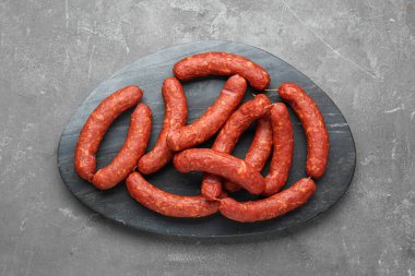 Delicious sausages on grey table, top view