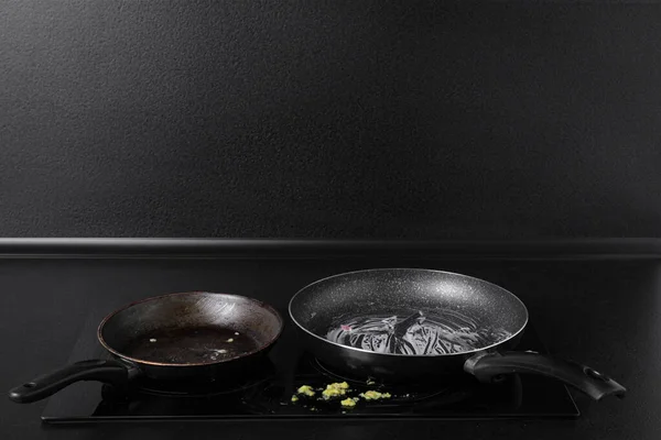 Dirty frying pans on cooktop in kitchen