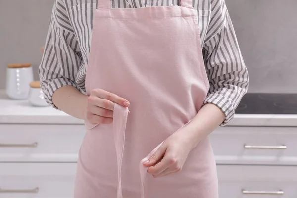 Woman Putting Pink Apron Kitchen Closeup — Stockfoto