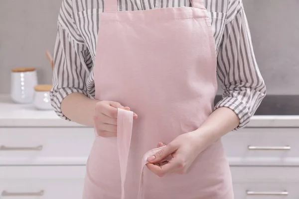 Woman Putting Pink Apron Kitchen Closeup — Stockfoto