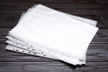 Punched pockets on brown wooden table, closeup