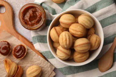 Delicious nut shaped cookies with boiled condensed milk on table, flat lay